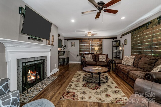 living room with a ceiling fan, recessed lighting, a fireplace with flush hearth, and wood finished floors