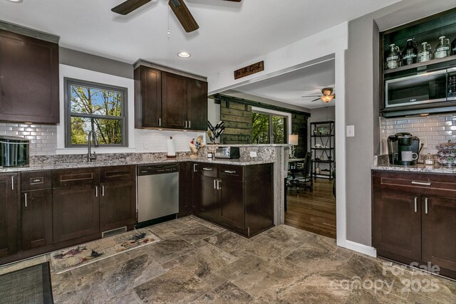 kitchen with stainless steel dishwasher, built in microwave, tasteful backsplash, light stone counters, and a ceiling fan
