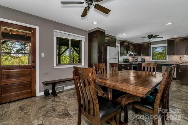 dining room featuring baseboards, stone finish floor, a ceiling fan, and recessed lighting