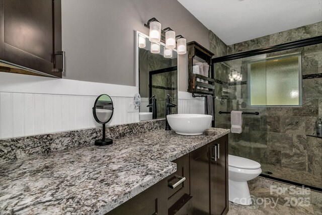 full bath with vanity, toilet, and a shower stall