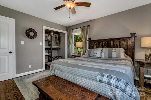 bedroom featuring baseboards, ceiling fan, wood finished floors, and a closet
