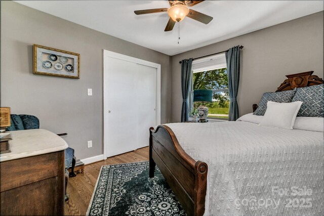 bedroom with baseboards, a ceiling fan, light wood-style flooring, and a closet
