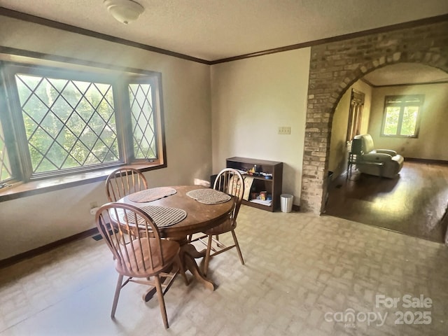 352 Edgemont Dr, Kings Mountain, NC 28086 - dining space with arched walkways, a textured ceiling, and ornamental molding
