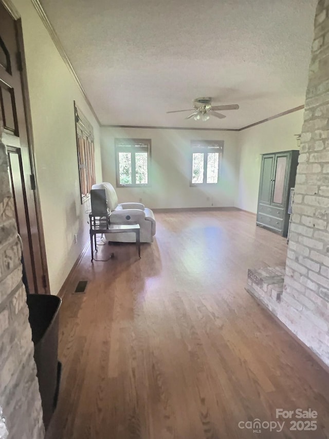 352 Edgemont Dr, Kings Mountain, NC 28086 - living room featuring wood finished floors, visible vents, a ceiling fan, crown molding, and a textured ceiling