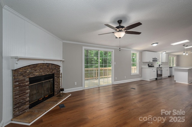 unfurnished living room with ornamental molding, a textured ceiling, a ceiling fan, and dark wood-type flooring
