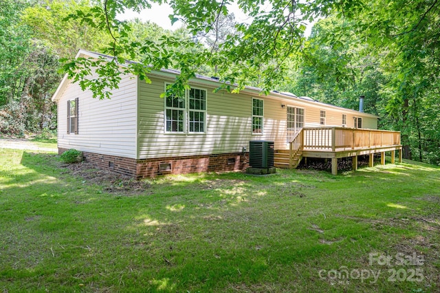 rear view of house with a yard, a deck, central AC, and crawl space