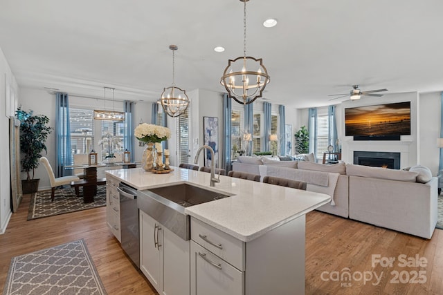 kitchen with a chandelier, stainless steel dishwasher, plenty of natural light, a sink, and recessed lighting
