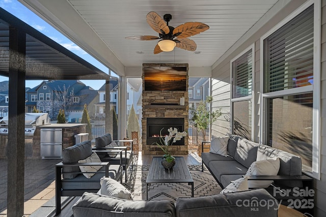 view of patio with an outdoor living space with a fireplace, a ceiling fan, and grilling area