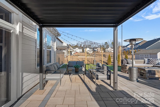 view of patio with an outdoor living space, fence, and a residential view