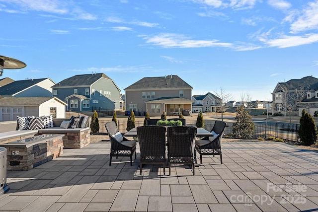 view of patio featuring a residential view, an outdoor fire pit, fence, and outdoor dining space