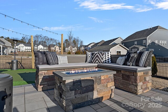 view of patio / terrace with a fire pit, a residential view, and fence