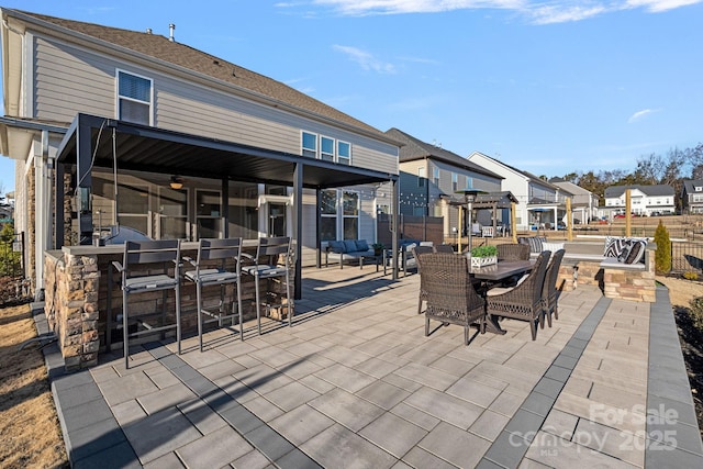 view of patio / terrace featuring a pergola, fence, a residential view, a ceiling fan, and outdoor dining space