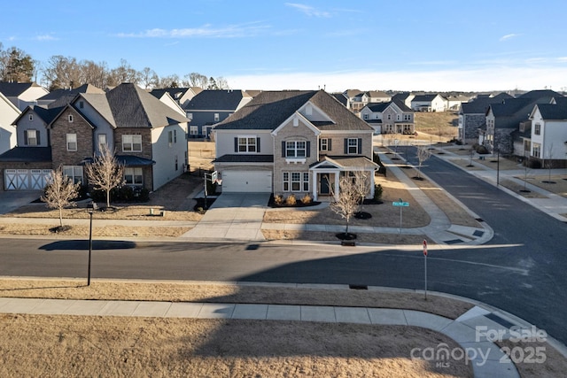 view of front facade featuring a residential view, an attached garage, and concrete driveway