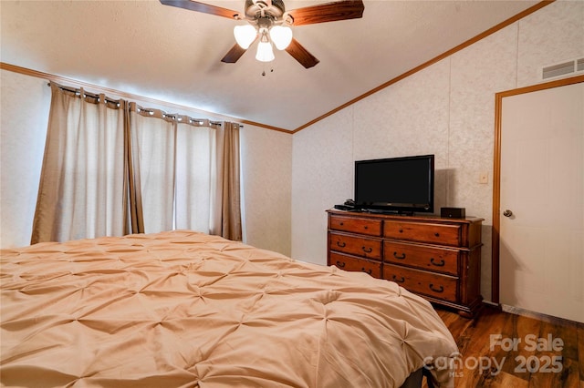 bedroom with vaulted ceiling, ornamental molding, ceiling fan, dark wood-style flooring, and visible vents