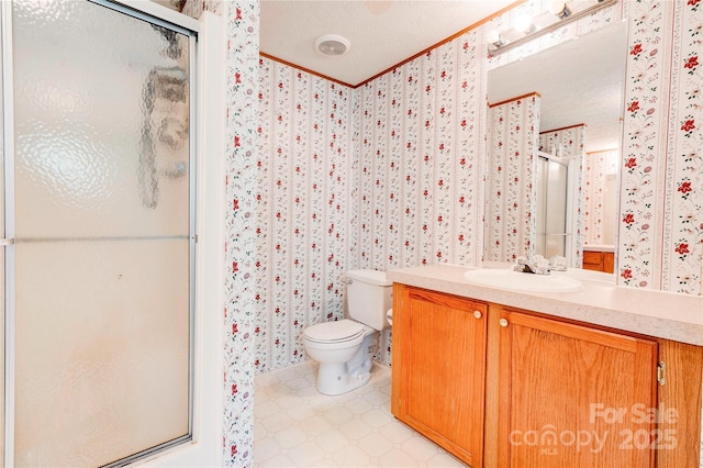 bathroom featuring a shower stall, vanity, toilet, a textured ceiling, and wallpapered walls