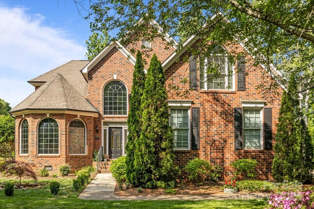 view of front of home featuring brick siding and a shingled roof