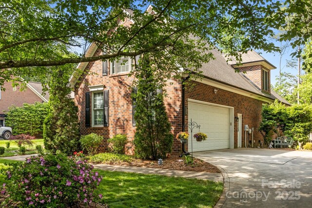 view of front of home with brick siding, a shingled roof, a garage, and driveway