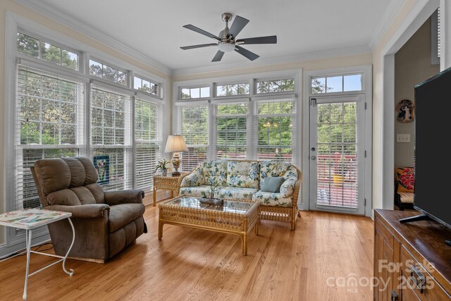 sunroom with crown molding, plenty of natural light, wood finished floors, and french doors