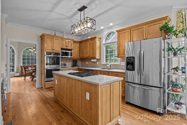 kitchen featuring light countertops, stainless steel appliances, an inviting chandelier, and a sink