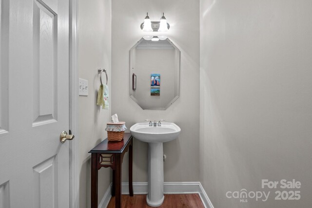 bathroom featuring a sink, baseboards, and wood finished floors