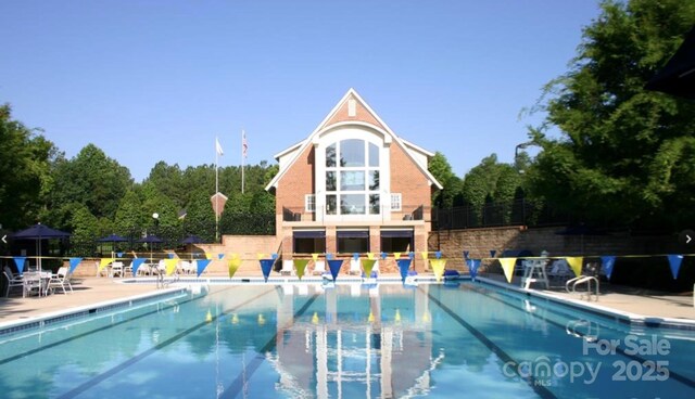 community pool featuring a patio and fence