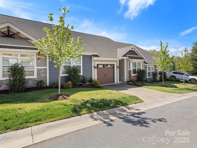 23 Heartleaf Cir, Arden, NC 28704 - view of front of property with an attached garage, concrete driveway, a front yard, stone siding, and roof with shingles