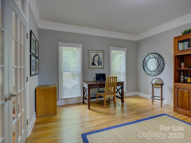 home office featuring baseboards, crown molding, french doors, and light wood-style floors