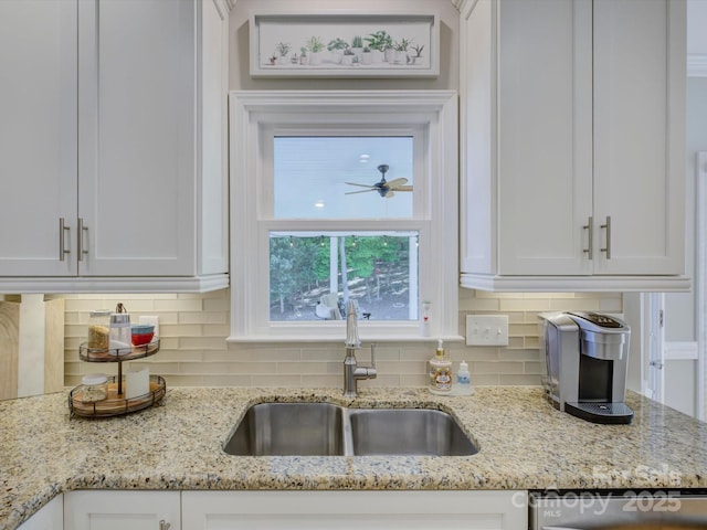 kitchen featuring white cabinets, backsplash, and a sink