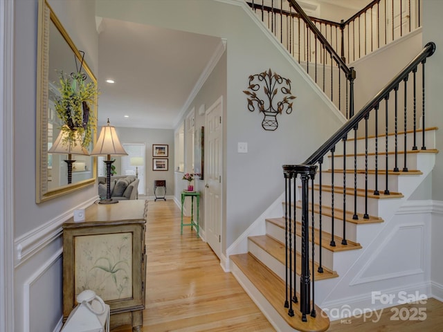 stairway featuring recessed lighting, wood finished floors, and ornamental molding