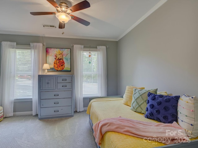bedroom with baseboards, visible vents, light colored carpet, ceiling fan, and crown molding