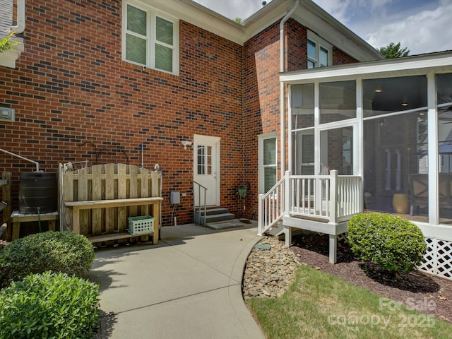 entrance to property featuring central AC unit and brick siding