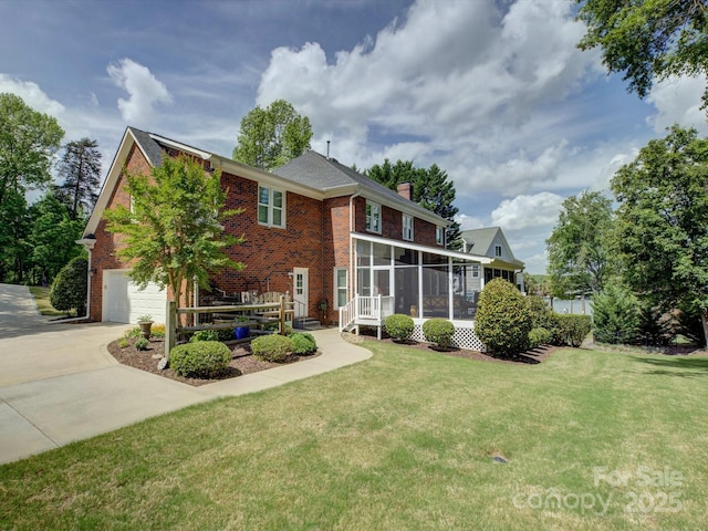 rear view of property featuring brick siding, a sunroom, a chimney, and driveway