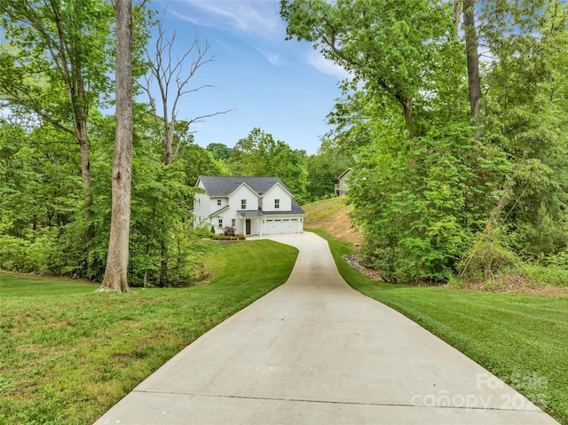 view of front of house featuring an attached garage, driveway, and a front lawn