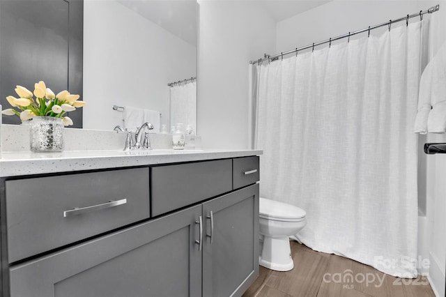 full bathroom featuring vanity, wood finished floors, shower / bath combination with curtain, and toilet