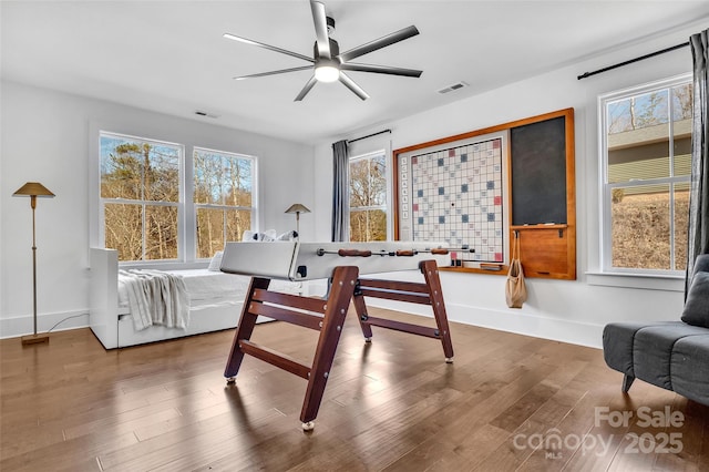 interior space featuring visible vents, baseboards, ceiling fan, and wood finished floors