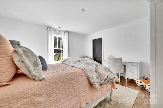 bedroom featuring wood finished floors and visible vents