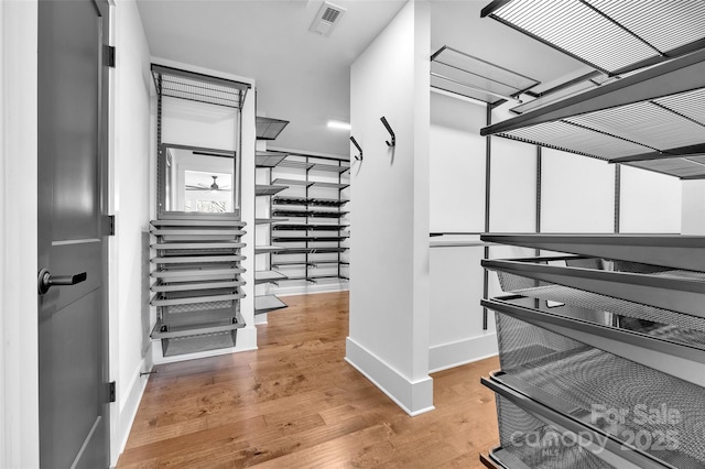 walk in closet with visible vents and wood finished floors