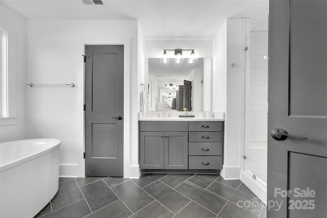 bathroom with tile patterned flooring, vanity, visible vents, a soaking tub, and a stall shower