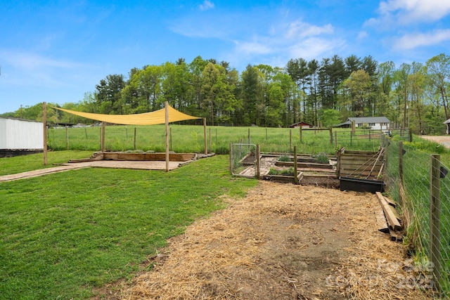 view of yard with fence and a vegetable garden