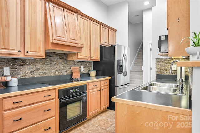 kitchen featuring tasteful backsplash, a sink, black appliances, light brown cabinets, and recessed lighting