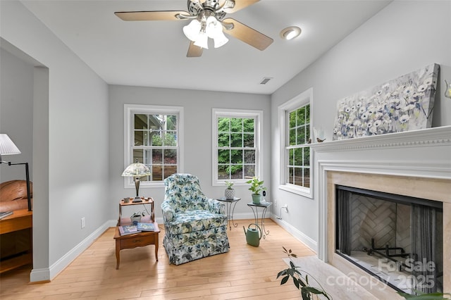 sitting room with visible vents, a ceiling fan, light wood-style flooring, and baseboards