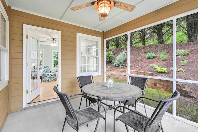 sunroom / solarium featuring outdoor dining area and ceiling fan