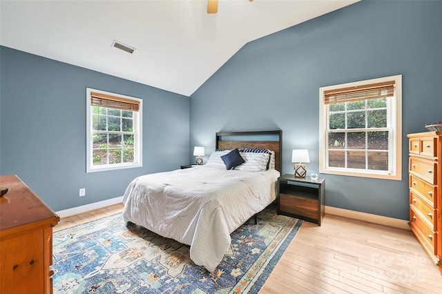 bedroom with baseboards, lofted ceiling, light wood-style flooring, and visible vents