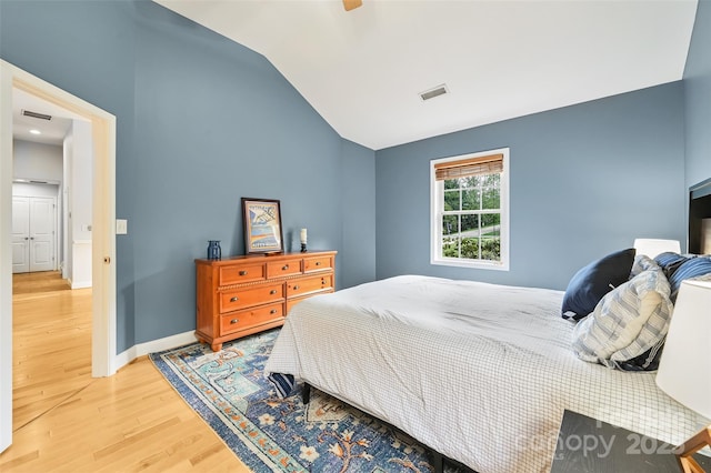 bedroom with light wood-style floors, a ceiling fan, baseboards, lofted ceiling, and visible vents