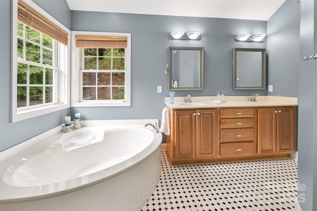 full bath with a sink, double vanity, and a bath
