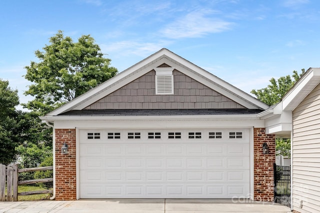 garage with driveway and fence