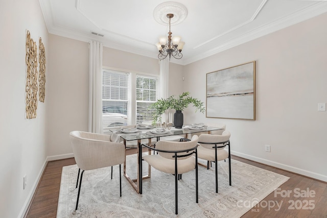 dining room featuring a chandelier, wood finished floors, and ornamental molding