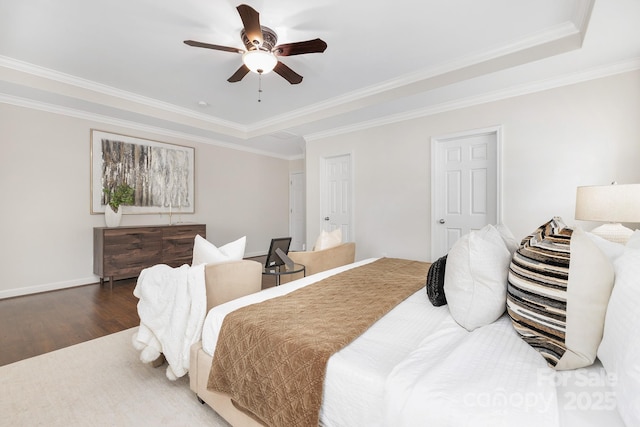 bedroom featuring wood finished floors, a ceiling fan, crown molding, and a raised ceiling