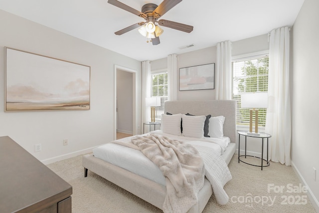 bedroom featuring baseboards, visible vents, light carpet, and multiple windows