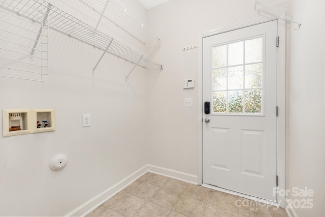 washroom featuring baseboards, hookup for a washing machine, and laundry area